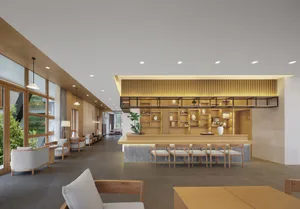 Modern lobby interior with wooden furniture and stone accents.