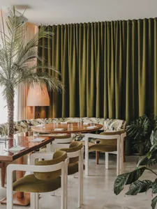 A modern restaurant interior with green globes and tropical plants.