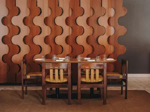 A modern restaurant interior featuring wooden furniture and a decorative wooden screen.