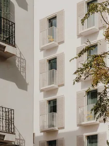 Modern buildings with white painted exteriors, metal shutters, and concrete foundations.