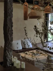 Living room with wooden furniture, cushions, and floral decor.