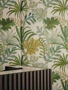 Close-up of a wall adorned with a tropical, jungle-themed fabric print, featuring green and teal foliage.