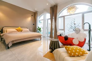 Modern bedroom with a large bed, white marble floor, and large windows