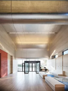 A sleek, modern lobby with concrete walls and wooden flooring.