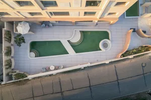 Modern minimalist swimming pool area with green water and concrete poolside.