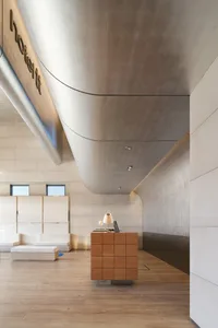 現代極簡大廳，混凝土牆面與地板，搭配俐落家具及接待桌。