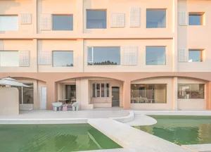 A minimalist residential building with a concrete exterior and a swimming pool.