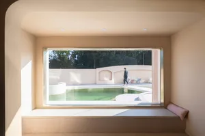 A minimalist terrace with a swimming pool surrounded by concrete and glass elements.
