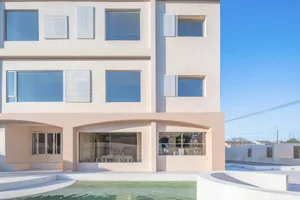 A modern building with concrete facade and large windows.