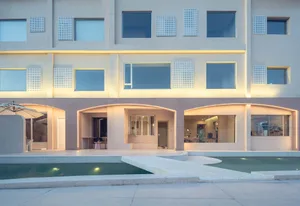 A modern hotel building with concrete and glass exterior materials.