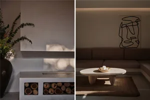 A minimalist concrete interior with a wooden coffee table and abstract wall art.