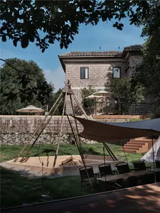 A modern outdoor space with a wooden teepee structure and a large awning providing shade.