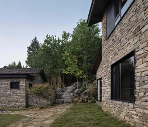 Modern architecture featuring a stone exterior with a pathway leading to a house.