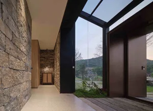 Modern residential entryway featuring stone walls and glass elements