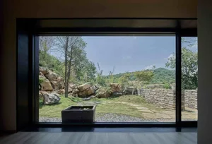 Outdoor space featuring natural stones and greenery within a landscape setting.