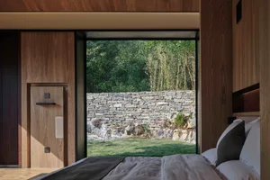 Minimalist bedroom featuring wood, stone, and concrete materials.