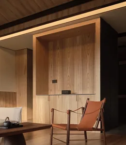 Modern living room featuring a wooden wall and a tan leather chair