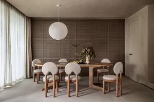 Modern dining room featuring a wooden table and chairs with linen upholstery.