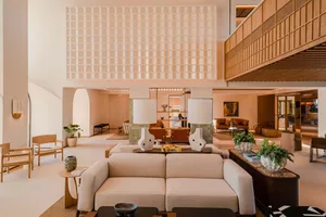 Modern and minimalist hotel lobby featuring neutral color tones and contemporary furniture.