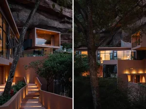 A modern house with concrete, glass, and cast stone exteriors illuminated at night.