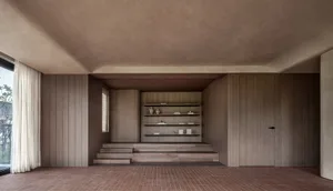 A modern living room featuring wooden paneling with built-in shelves and a step-down seating area.