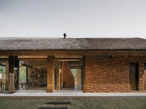 A modern residential architect with wooden walls and a thatched roof.