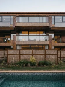 Modern residential building with large glass windows and wooden elements.