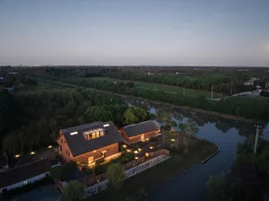 A modern residential brick house with large windows and a roofline designed to capture natural light.