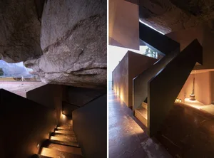 Modern residential staircase with marble steps against a concrete wall and ceiling, illuminated by warm lighting.