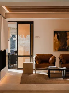 A modern restaurant with leather furniture and stone details.