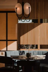 Modern restaurant interior with wood-paneled walls and marble countertops.