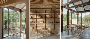 Interior of a minimalist coffee shop featuring wooden furniture, shelves, and skylights.