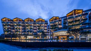 A modern apartment complex at night with illuminated balconies and planters