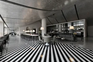 A modern bar lounge with metallic ceiling and black and white striped floor.