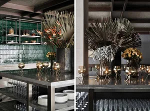 Modern bar interior with glass shelves, metal accents, and decorative metal plants.
