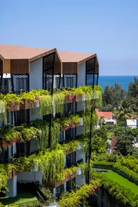 A modern building adorned with lush green plants and flowers.