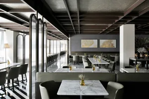 Modern restaurant interior with marble tables, leather booths, and contemporary decor.