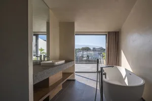 Modern bathroom featuring a concrete floor, minimalist design, and window with city view.