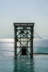 A modern glass structure emerging from the water