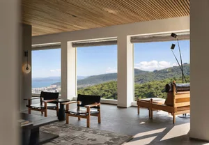 A modern living room with wooden furniture, glass windows, and leather accents.