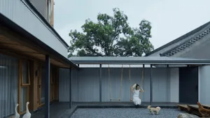 A modern house with a metal roof and a courtyard with a swing.