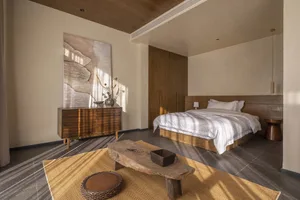 Modern minimalist bedroom featuring wooden furniture and a neutral color palette.