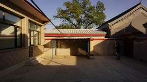 現代住宅中庭的混凝土地面、磚牆與金屬欄杆。