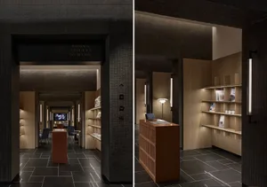 A modern restaurant featuring wooden shelves and black tiles on the floor.