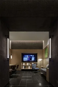 A modern interior design featuring a dark-themed TV room with a wooden accent wall, bookshelves, and a comfortable seating ar