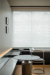 Modern, minimalist interior design featuring a white room with a metal table and bench seating.