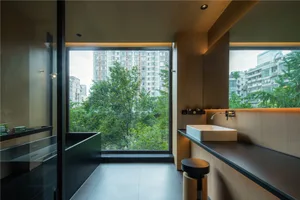 A modern bathroom with a glass window showcasing a cityscape view.