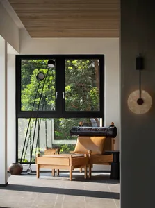 Contemporary living room with wooden furniture, leather accents, and glass elements.