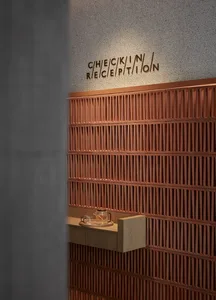 A modern reception desk with a wooden design, featuring a check-in sign above it.