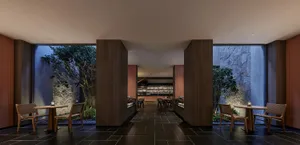 A modern restaurant interior with dark tones, wooden tables, chairs, and stone walls.